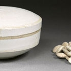 A GLAZED WHITE PORCELAIN BOX AND COVER WITH GAME COUNTERS