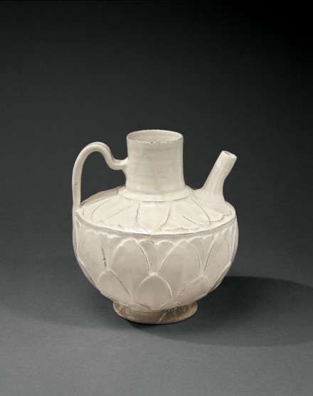 A WHITE-GLAZED CIZHOU POTTERY LOTUS-PETAL CARVED EWER