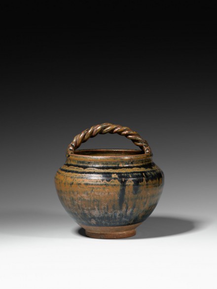 A BROWN-AND-BLACK-GLAZED POTTERY JAR WITH HANDLE