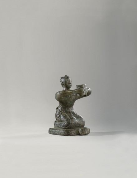 AN ARCHAIC BRONZE KNEELING FIGURE