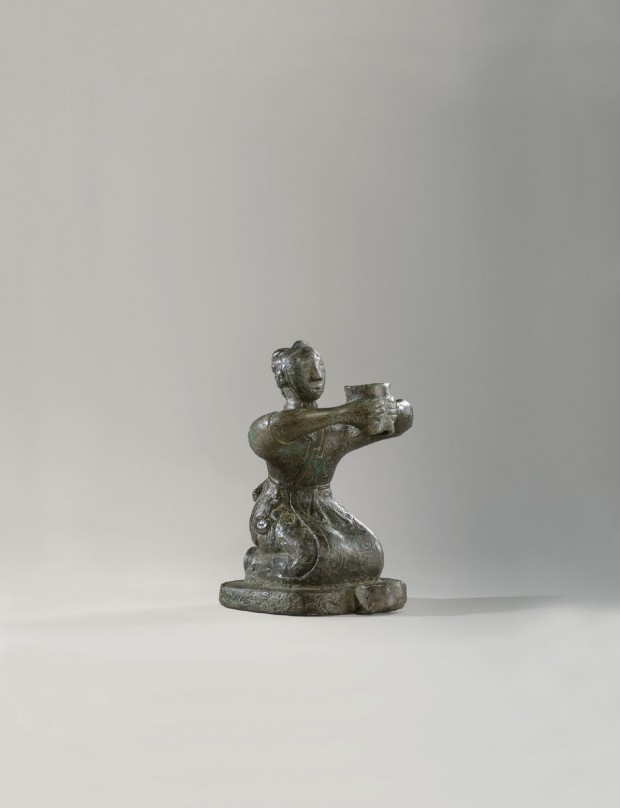 AN ARCHAIC BRONZE KNEELING FIGURE