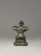 AN ARCHAIC BRONZE KNEELING FIGURE