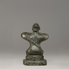 AN ARCHAIC BRONZE KNEELING FIGURE