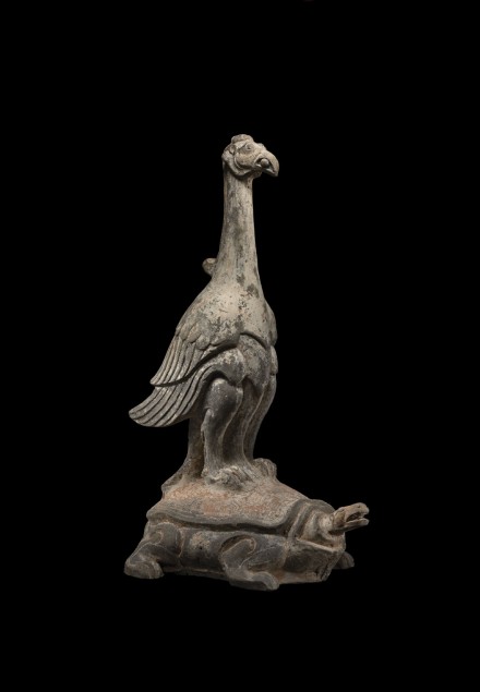 A PAINTED POTTERY GROUP OF A PHOENIX STANDING ON A TORTOISE