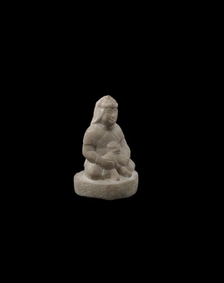 A SMALL WHITE MARBLE SEATED FIGURE OF A ‘FOREIGNER’ WITH LION CUB