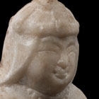 A SMALL WHITE MARBLE SEATED FIGURE OF A ‘FOREIGNER’ WITH LION CUB