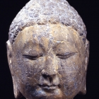 A GRAY LIMESTONE HEAD OF THE BUDDHA