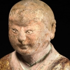 A PAINTED AND GILDED STONE FIGURE OF A LUOHAN