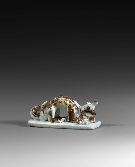 A QINGBAI GLAZED IRON-BROWN SPLASHED PORCELAIN DRAGON-FORM BRUSHREST