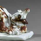 A QINGBAI GLAZED IRON-BROWN SPLASHED PORCELAIN DRAGON-FORM BRUSHREST