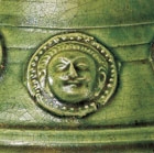 A GREEN-GLAZED POTTERY COVERED VASE WITH APPLIED MEDALLIONS