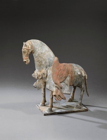 A PAINTED POTTERY FIGURE OF A SADDLED HORSE