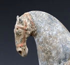 A PAINTED POTTERY FIGURE OF A SADDLED HORSE