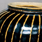 A WHITE-RIBBED BLACK-GLAZED GLOBULAR JAR