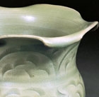 A CARVED YAOZHOU CELADON JAR WITH FOLIATE MOUTH (ZUN)