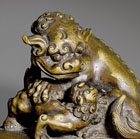 A BRONZE WEIGHT SURMOUNTED BY A BUDDHIST LION AND CUB