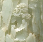 A MOTTLED PALE CELADON JADE BRUSHPOT