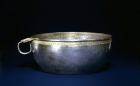 A CHASED AND PARCEL-GILT SILVER BOWL WITH FLANGE HANDLE