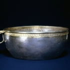 A CHASED AND PARCEL-GILT SILVER BOWL WITH FLANGE HANDLE
