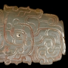 A JADE ORNAMENT WITH ENTWINED HUMAN HEADS AND DRAGONS DESIGN