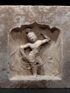 A LIMESTONE BLOCK WITH DANCER IN A NICHE