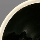 A BLACK-GLAZED CONICAL BOWL WITH WHITE RIM