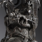 A BRONZE SEATED GUANYIN WITH A DRAGON