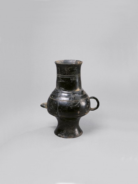 A NEOLITHIC BURNISHED BLACK POTTERY VESSEL WITH TWO HANDLES