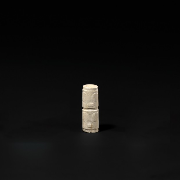A CARVED NEOLITHIC JADE CYLINDRICAL BEAD