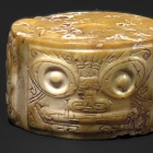 A NEOLITHIC JADE ORNAMENT CARVED WITH MASKS