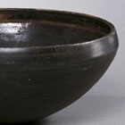 A BURNISHED BLACK POTTERY ALMS BOWL (PATRA)