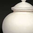 A GLAZED WHITE STONEWARE JAR AND COVER