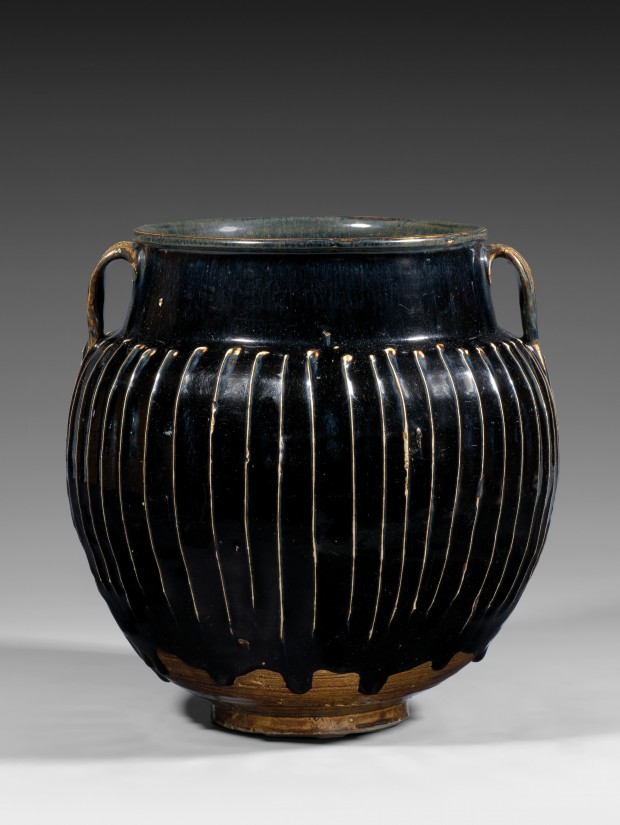 A LARGE BLACK-GLAZED WHITE-RIBBED STONEWARE JAR