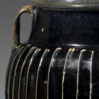 A LARGE BLACK-GLAZED WHITE-RIBBED STONEWARE JAR