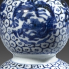 A SMALL MING BLUE AND WHITE PORCELAIN DOUBLE-GOURD ‘DRAGON’ VASE