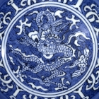 A MING REVERSE-DECORATED BLUE AND WHITE PORCELAIN ‘DRAGON’ BOWL