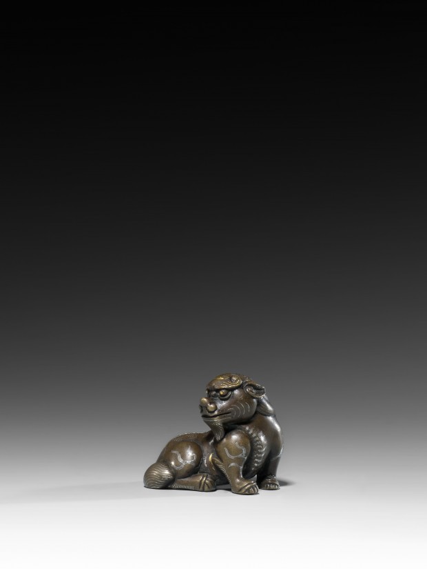 A GOLD AND SILVER INLAID BRONZE MYTHICAL BEAST PAPERWEIGHT