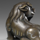 A GOLD AND SILVER INLAID BRONZE MYTHICAL BEAST PAPERWEIGHT
