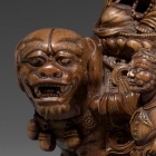 AN IMPERIAL BOXWOOD CARVING OF MANJUSHRI SEATED ON A LION