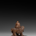 AN IMPERIAL BOXWOOD CARVING OF MANJUSHRI SEATED ON A LION