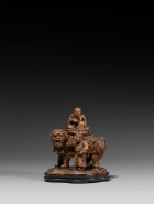 AN IMPERIAL BOXWOOD CARVING OF MANJUSHRI SEATED ON A LION