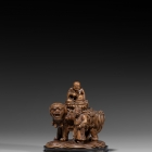 AN IMPERIAL BOXWOOD CARVING OF MANJUSHRI SEATED ON A LION